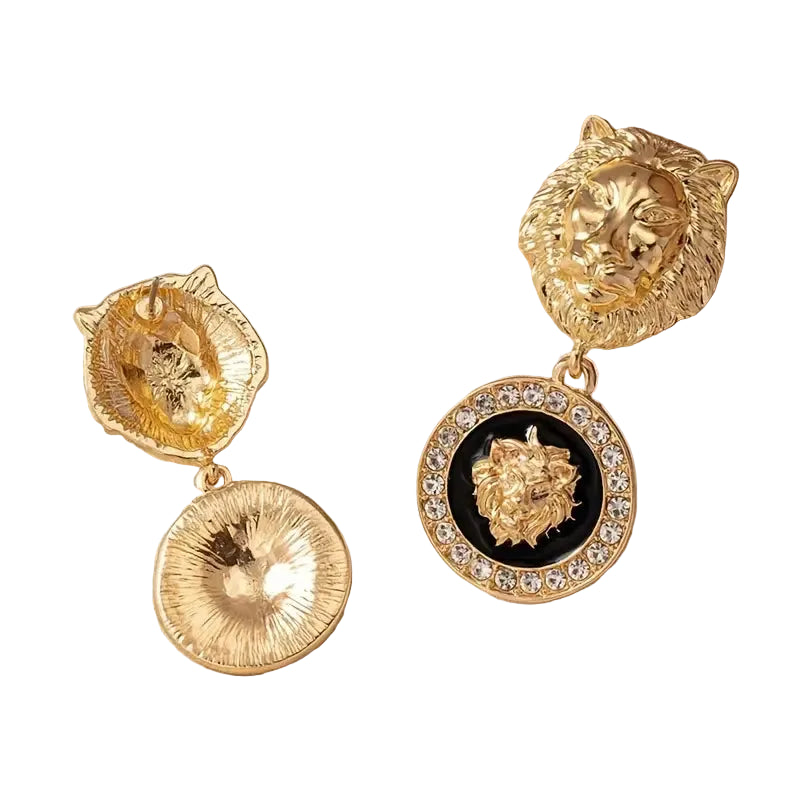 Gold lion head earrings with black center on a beige background