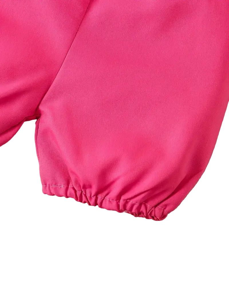 Close-up of bright pink pants on a wooden floor