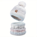 Light blue knit beanie with pom-pom and matching scarf on a white background