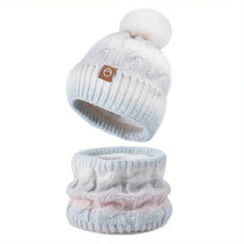 Light blue knit beanie with pom-pom and matching scarf on a white background