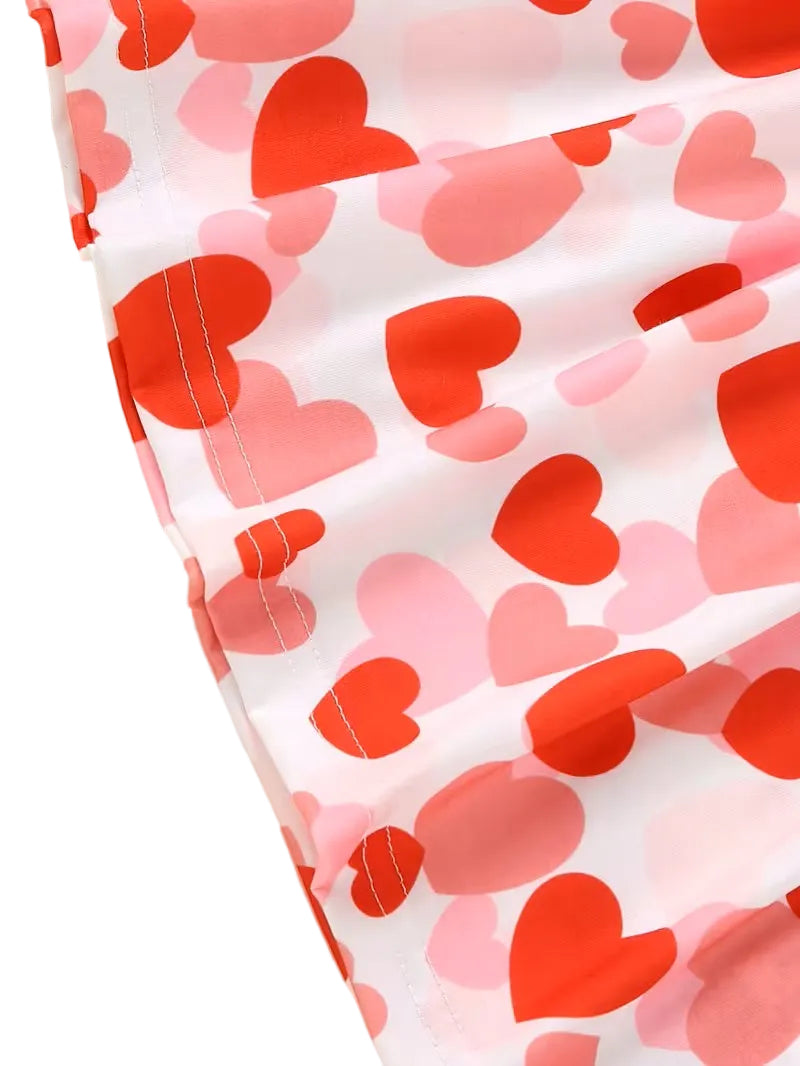 Close-up of fabric with red and pink heart pattern on a white background