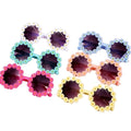 A collection of colorful round sunglasses with decorative patterns around the lens.