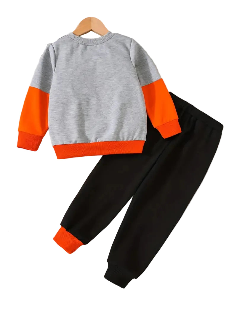 Children's outfit with gray and orange top and black pants on a white background