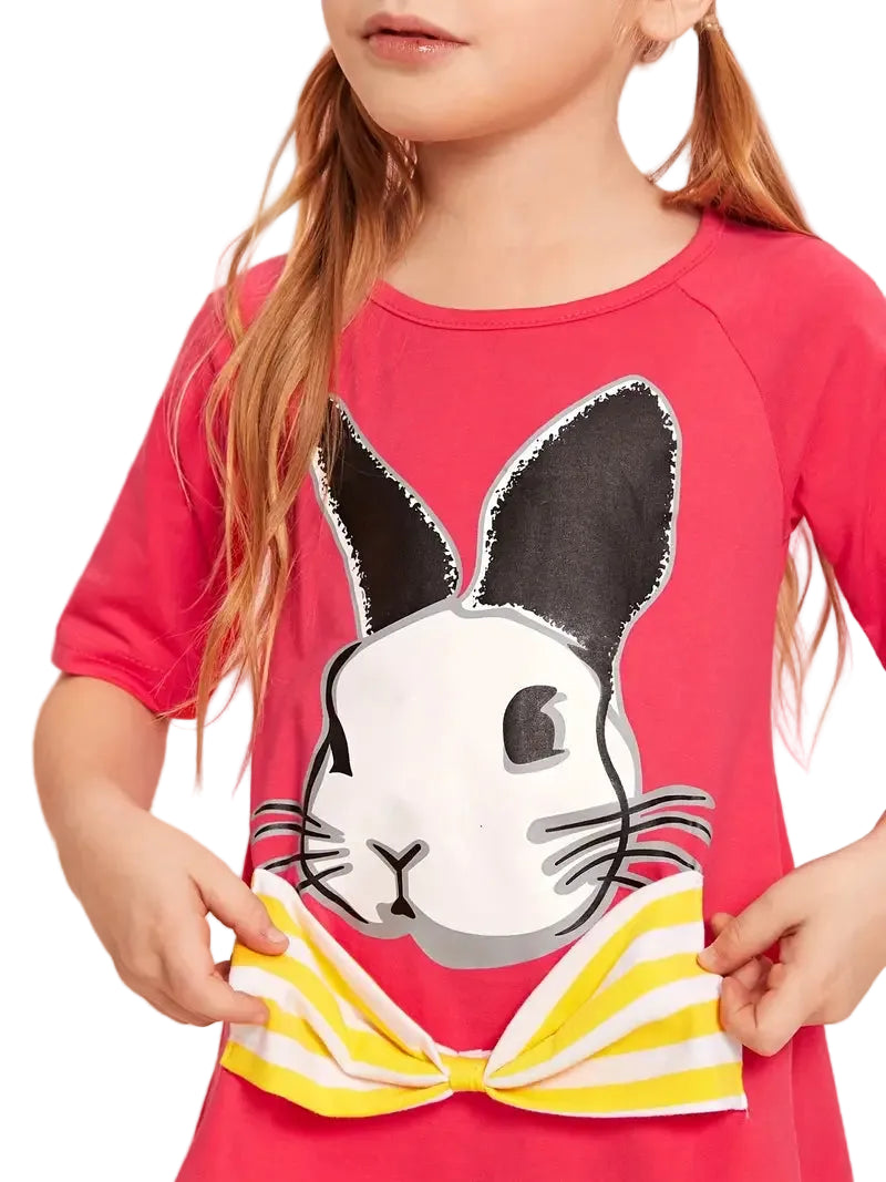 Child wearing a pink shirt with a cartoon rabbit design on a pink background