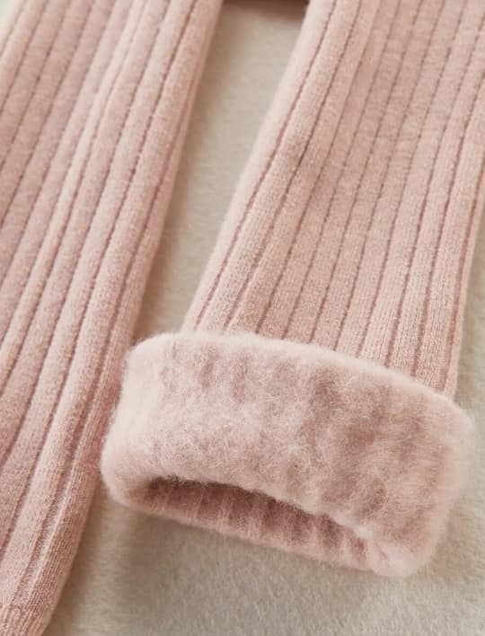 Close-up of a pink textured garment with fluffy trim on a light background