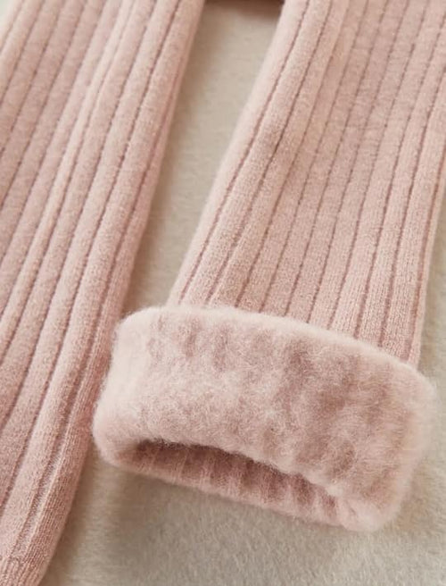 Close-up of a pink textured garment with fluffy trim on a light background