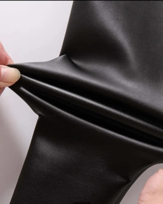 Close-up of black fabric being stretched with a white background