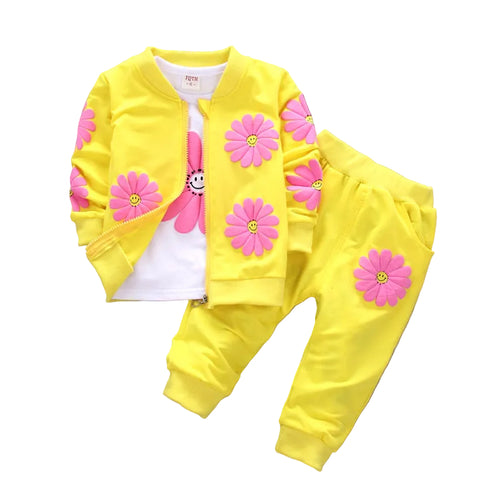 Yellow children's outfit with pink flower designs on a white background