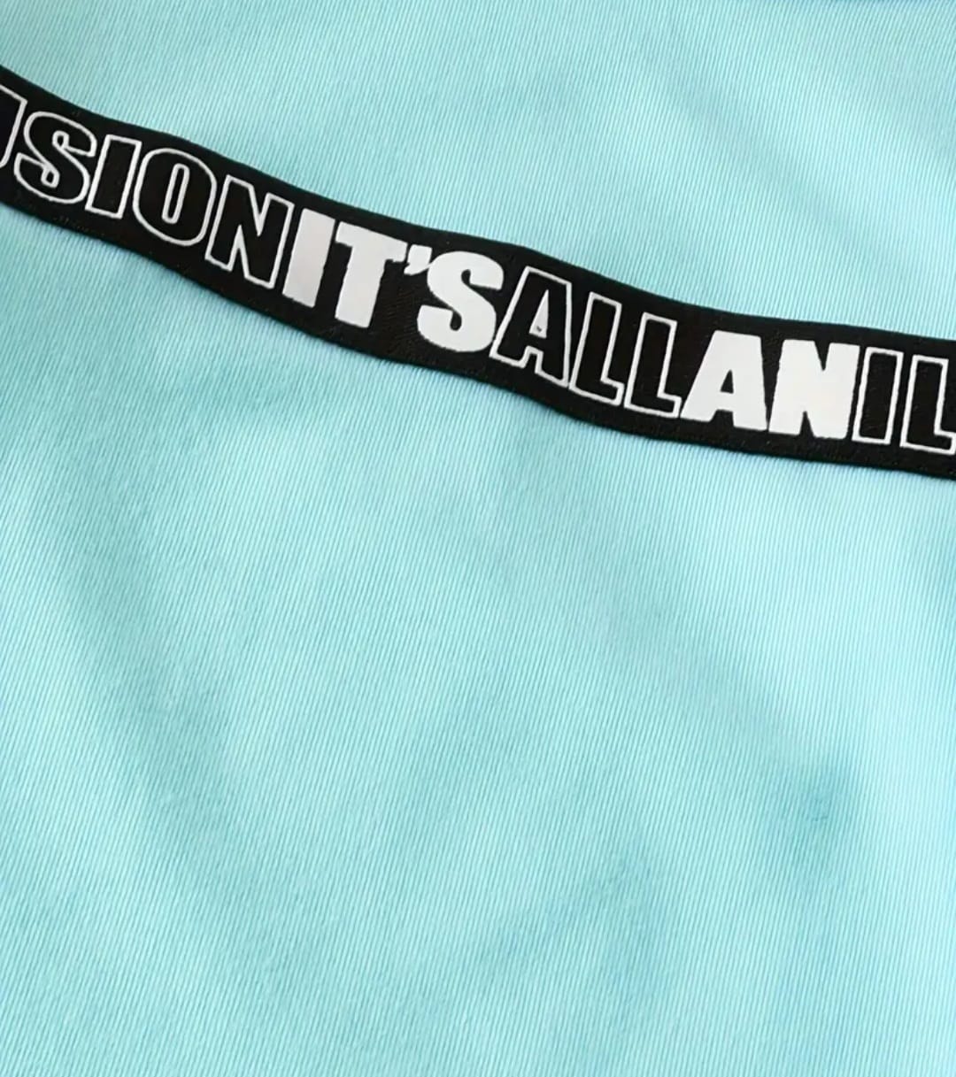 Light blue fabric with a black waistband displaying white text.