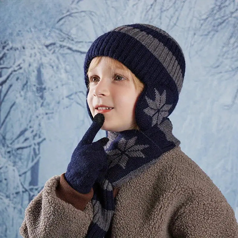 Child wearing a navy blue knit hat, scarf, and gloves against a textured blue background