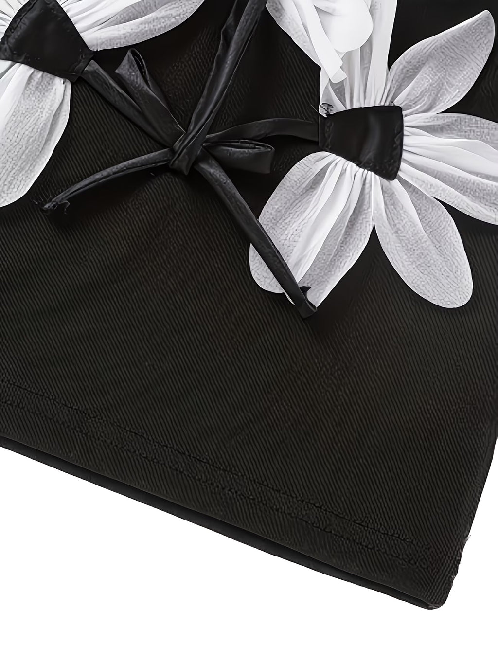 Black fabric with white floral patterns and black ribbons on a white background