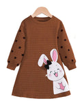 Brown dress with bunny design on a hanger against a white background