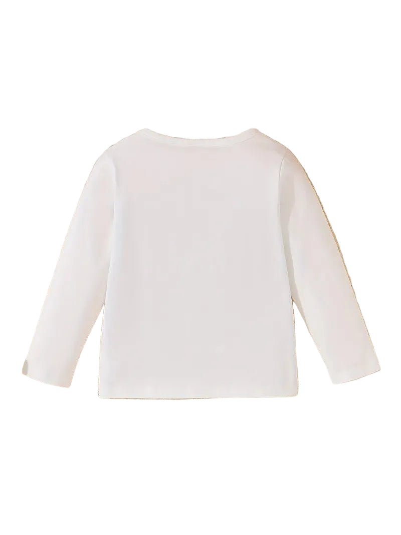White long-sleeve top on a textured surface with sunglasses, flowers, and shoes around.