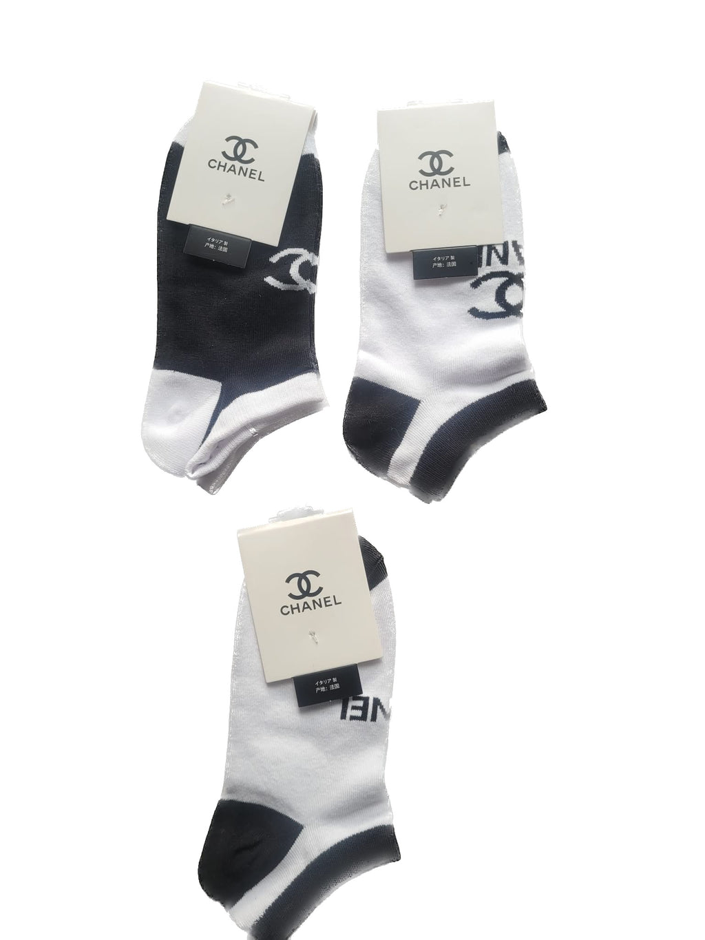 Three pairs of black and white socks with Chanel branding on a white background