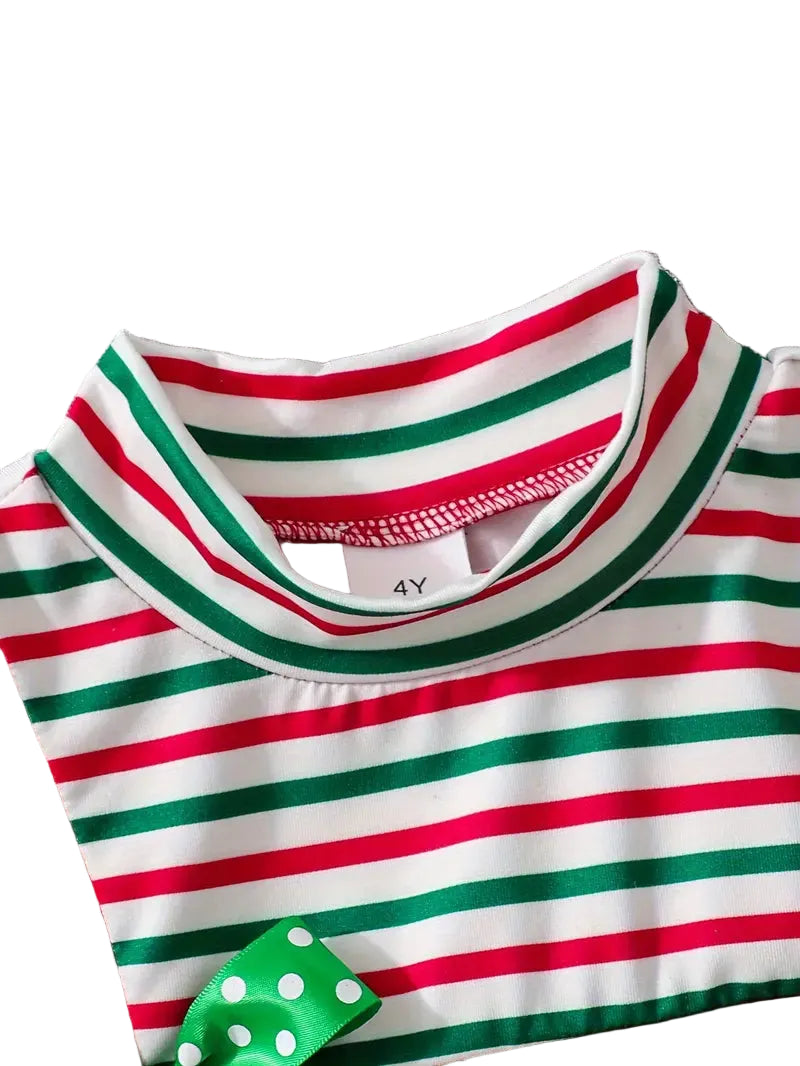 Close-up of a child's red, green, and white striped shirt with a green dice design on a gray fabric background.