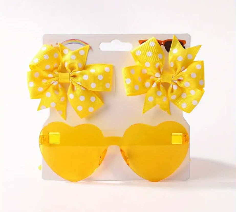 Yellow heart-shaped sunglasses with polka dot bows on a white background