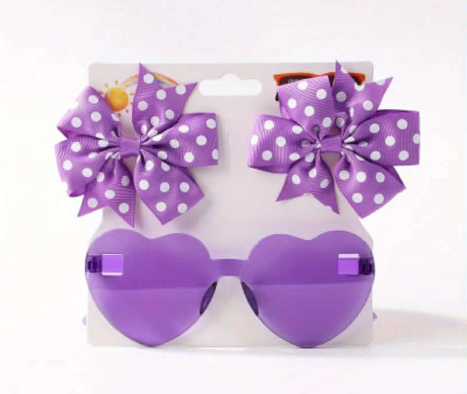 Purple heart-shaped sunglasses with matching bows on a white background