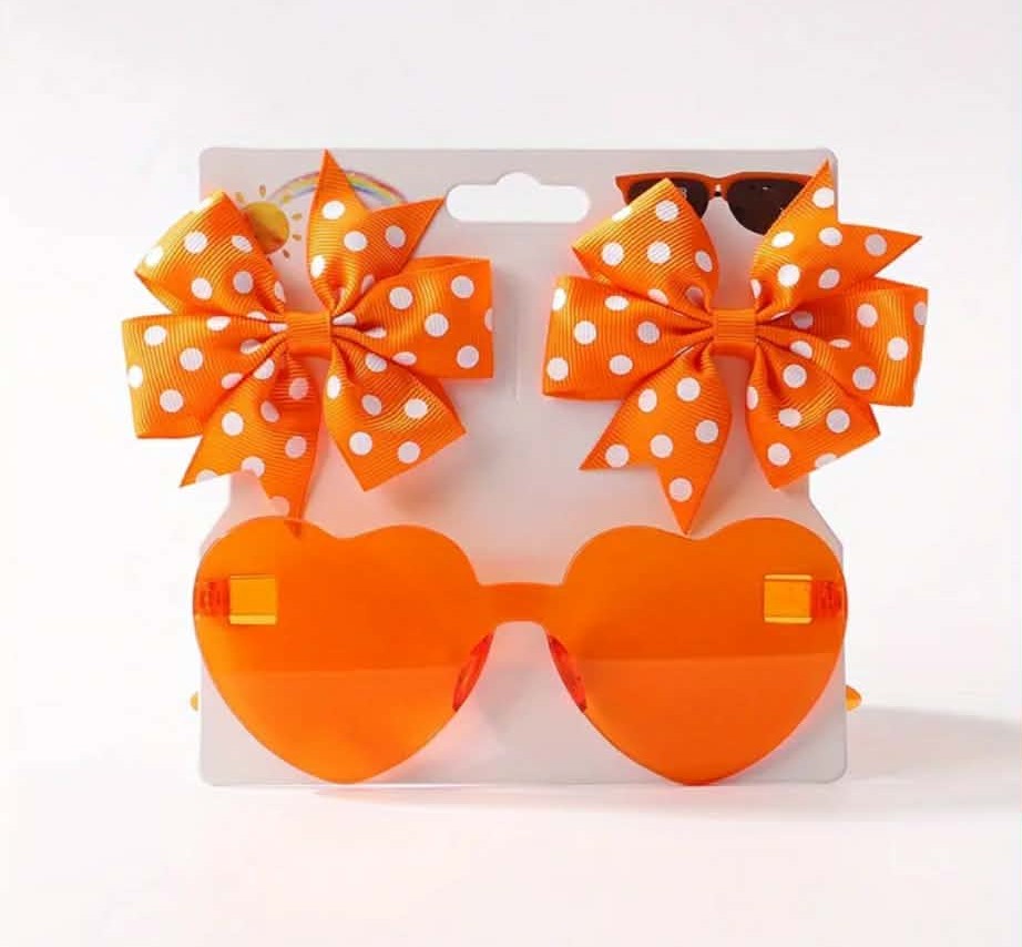 Orange sunglasses with polka dot bows on a white background