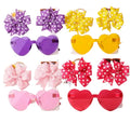 Colorful heart-shaped sunglasses with polka dot bows on a white background