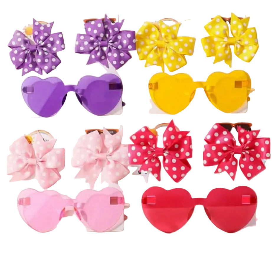 Colorful heart-shaped sunglasses with polka dot bows on a white background