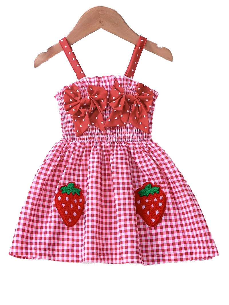 Red and white checkered dress with bow straps and strawberry appliqués on a hanger.