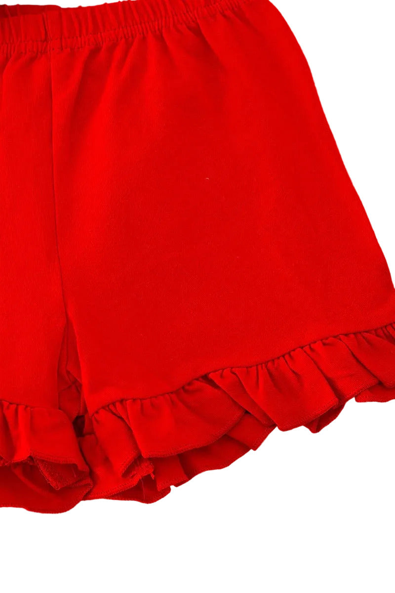 Red shorts with ruffled hem on a white fluffy surface