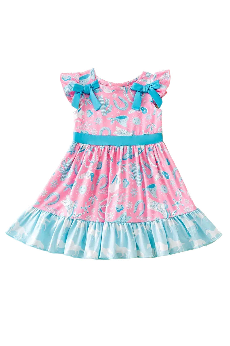 Pink and blue dress with bows on a fluffy beige surface