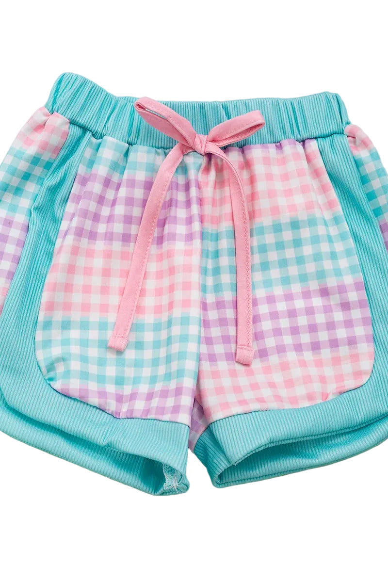 Pastel checkered shorts with a pink tie on a light background