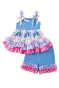 Children's boutique outfit with a blue top and shorts featuring ruffles on a fluffy white surface. Adorable girls set 