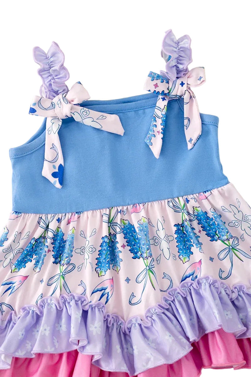 Children's dress with floral pattern and blue top on a fluffy beige background