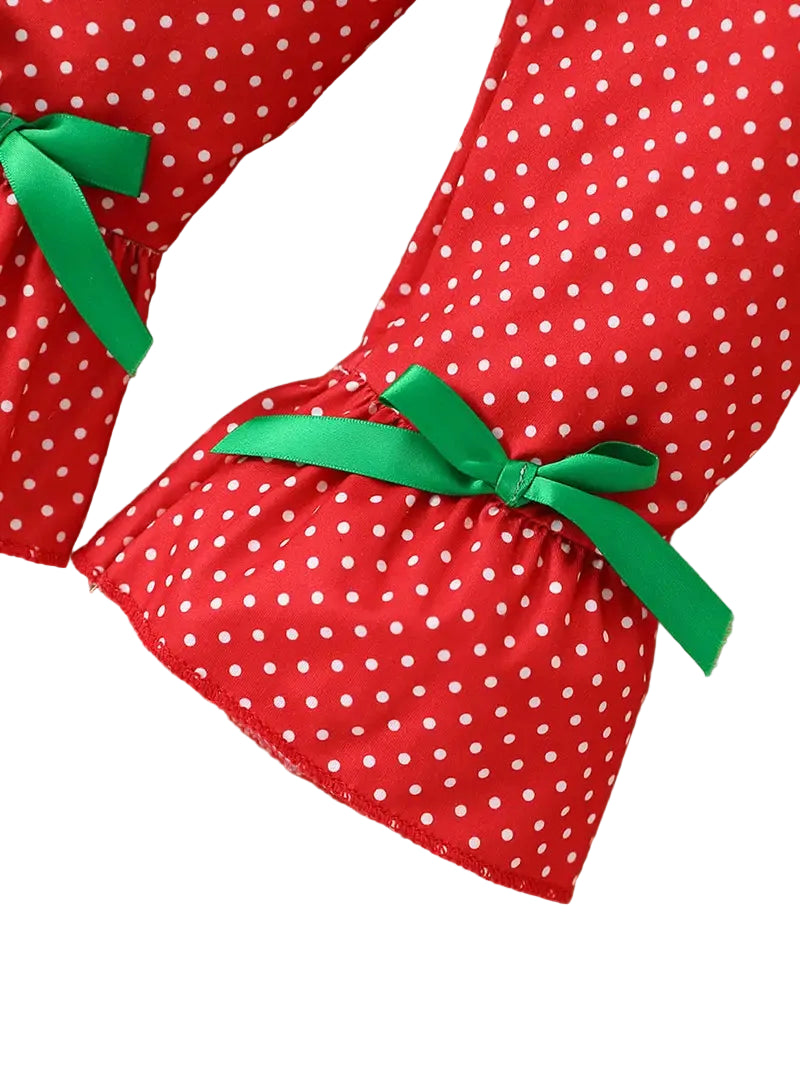 Red polka dot dress with green ribbons on a white background