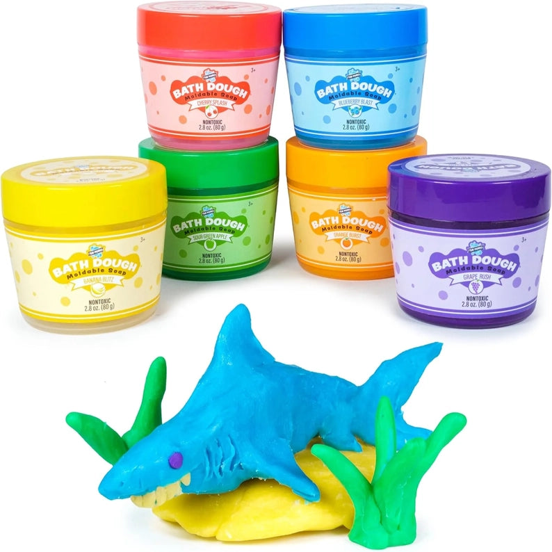 Colorful jars of bath dough with a blue shark toy on a white background