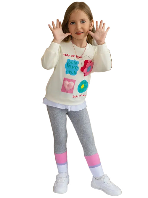Young girl wearing a white sweatshirt with colorful designs and gray leggings on a white background