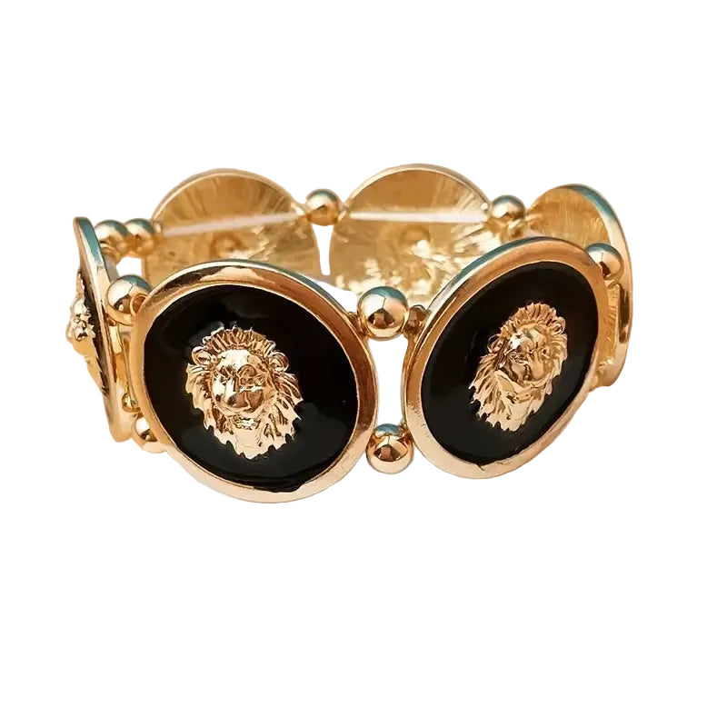 Gold bracelet with black stones featuring lion head designs on a beige background