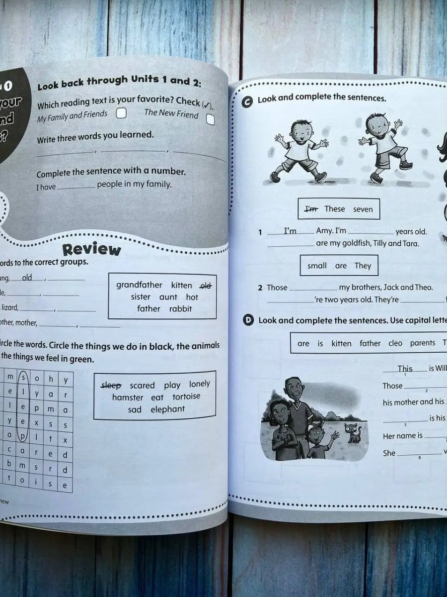 Open educational book with text and illustrations on a wooden surface