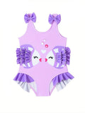 Purple children's swimsuit with cartoon face and ruffles on a white background