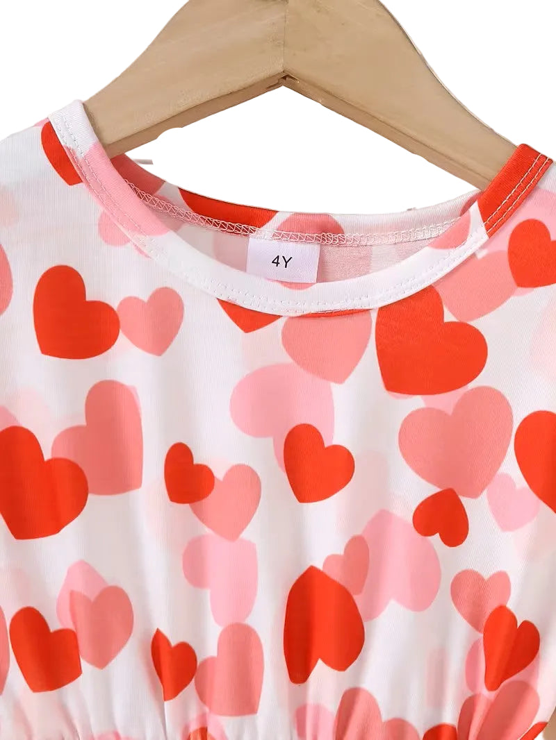 Children's shirt with red and pink heart pattern on a hanger