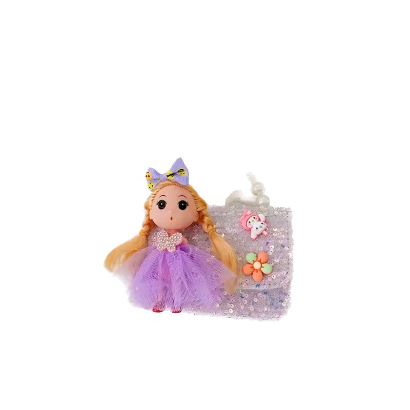 Toy doll with purple outfit and blonde hair next to a small suitcase on a white background