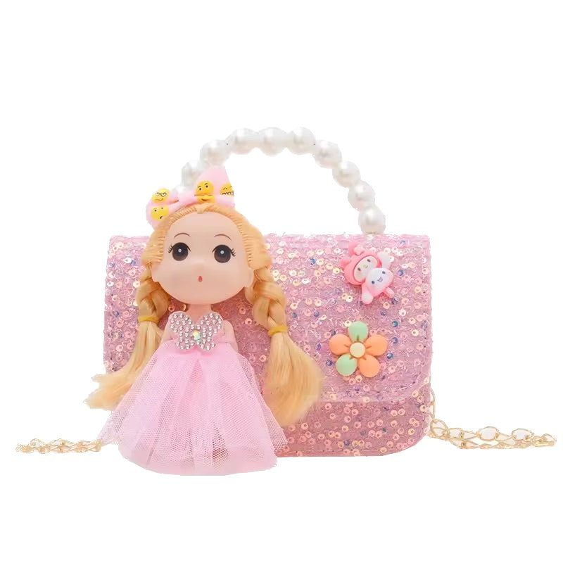 Pink handbag with a doll wearing a pink dress on a white background