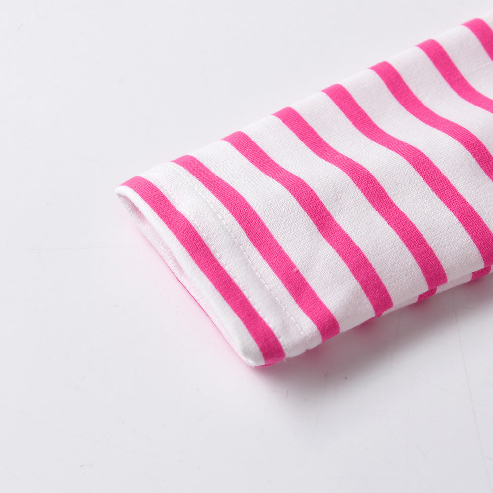 Roll of pink and white striped fabric on a light gray background