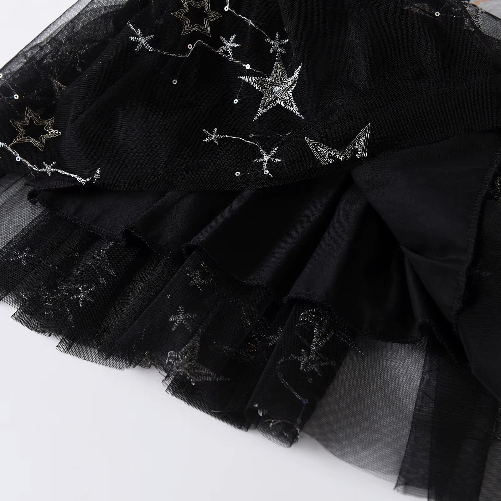 Black tulle skirt with star-shaped embellishments on a white background