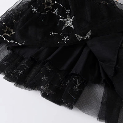 Black tulle skirt with star-shaped embellishments on a white background
