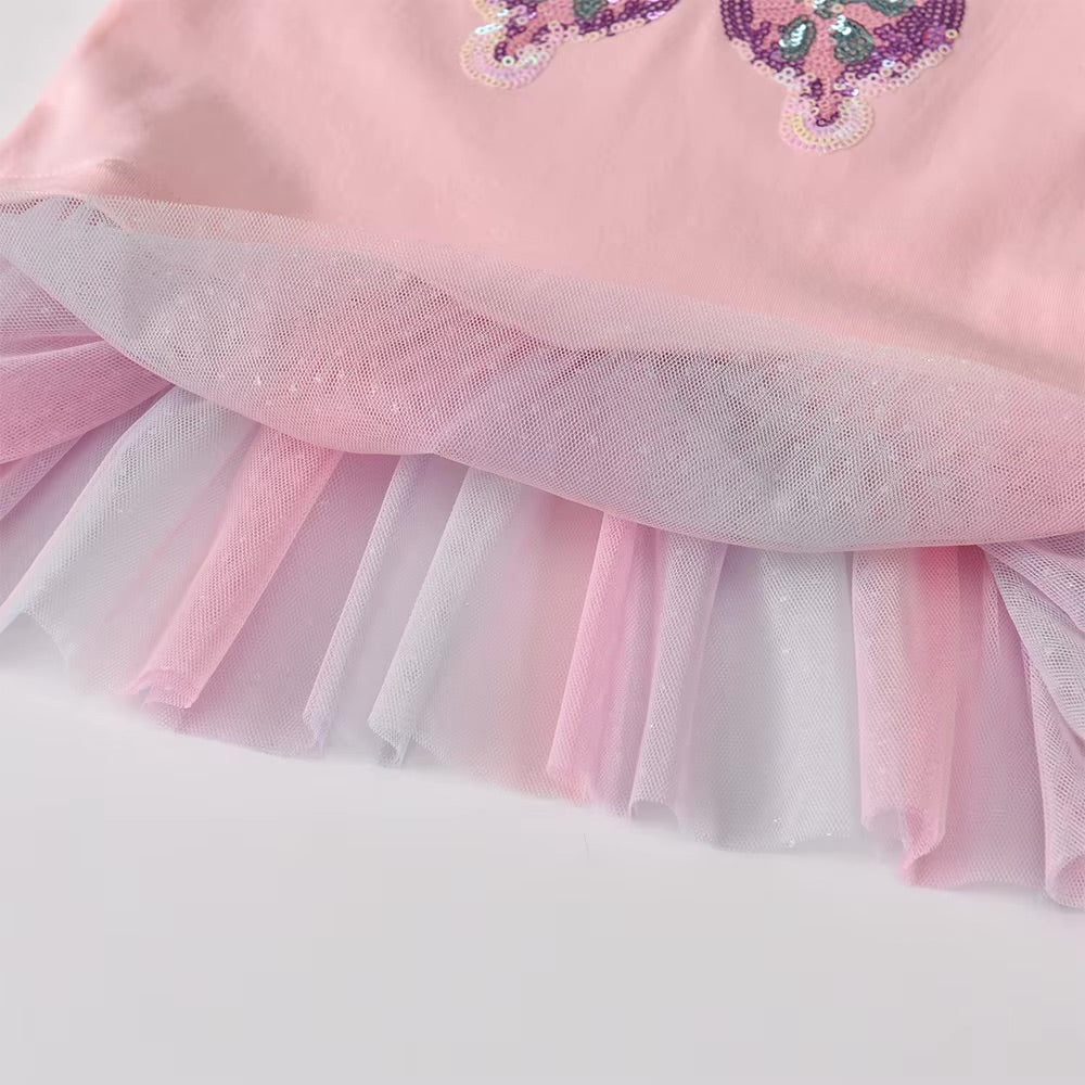 Close-up of a pink dress with a tulle skirt on a white background