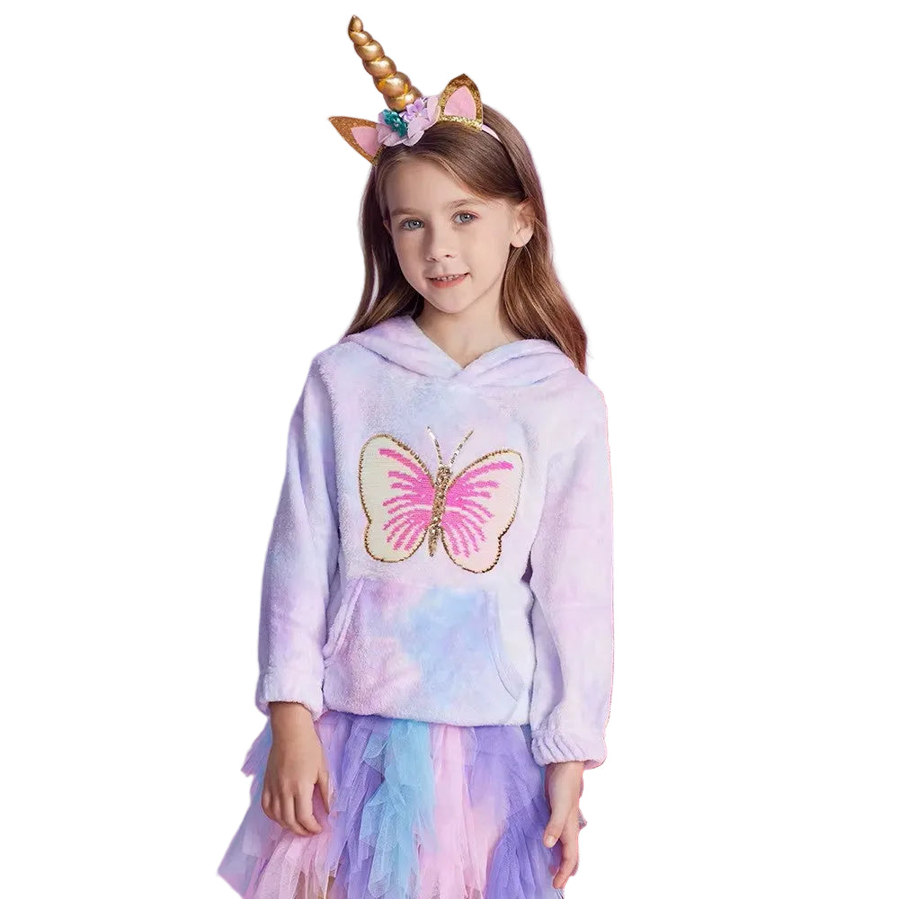 Young girl wearing a hoodie with a butterfly design and a unicorn headband on a white background