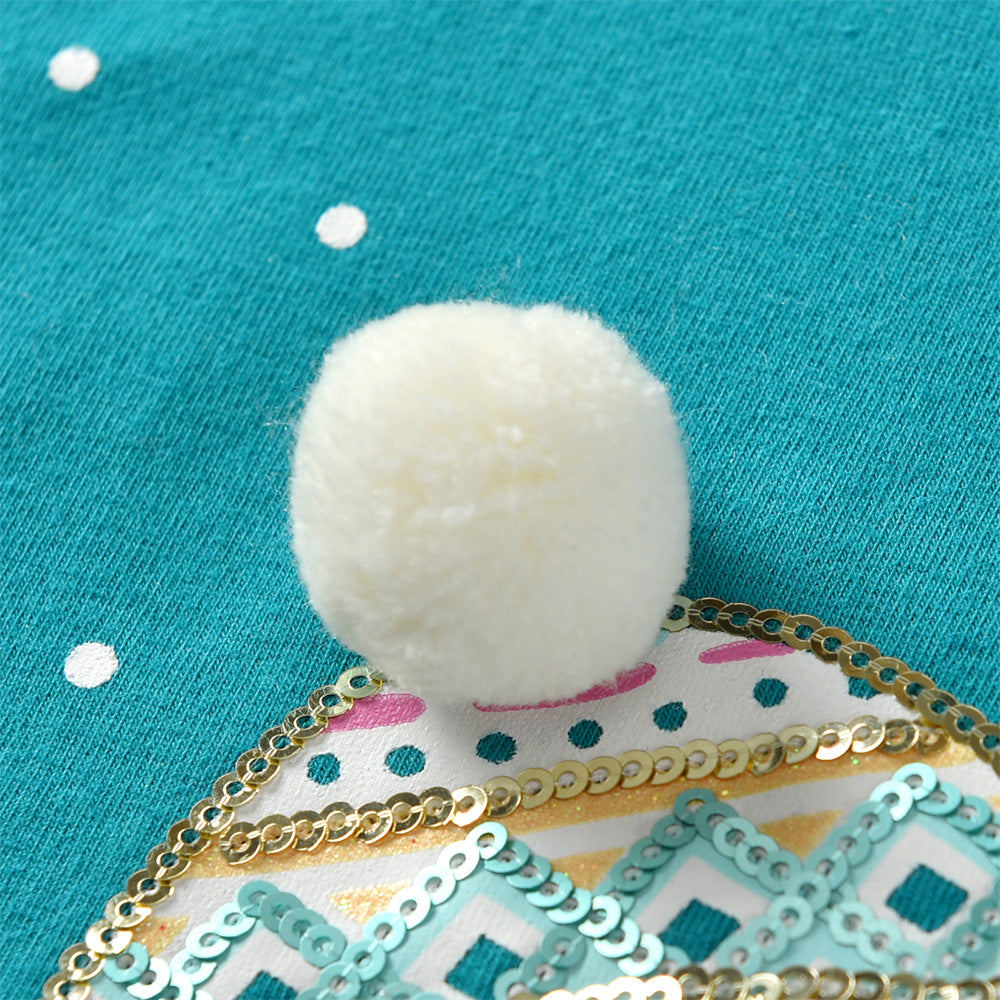 Close-up of a white pom-pom on a decorative fabric with a blue background