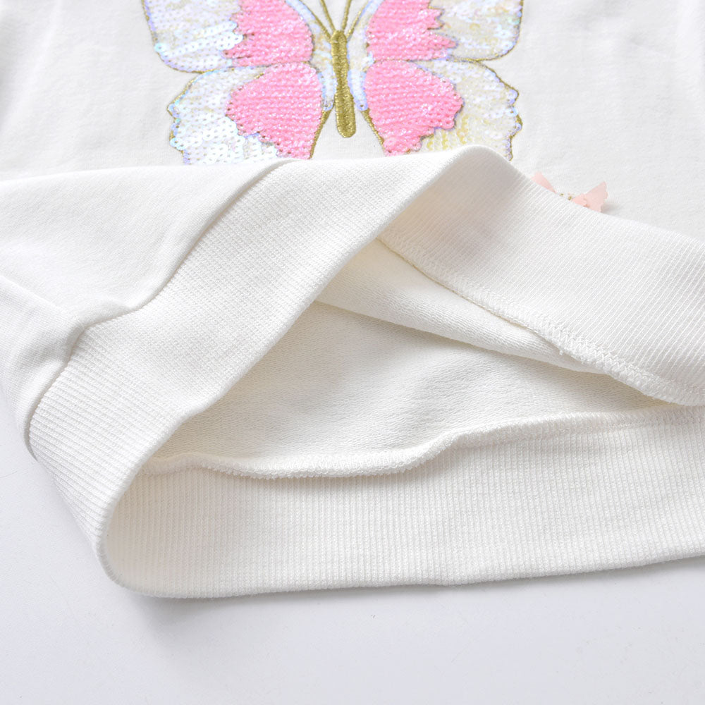 White fabric with a pink butterfly embroidered on it