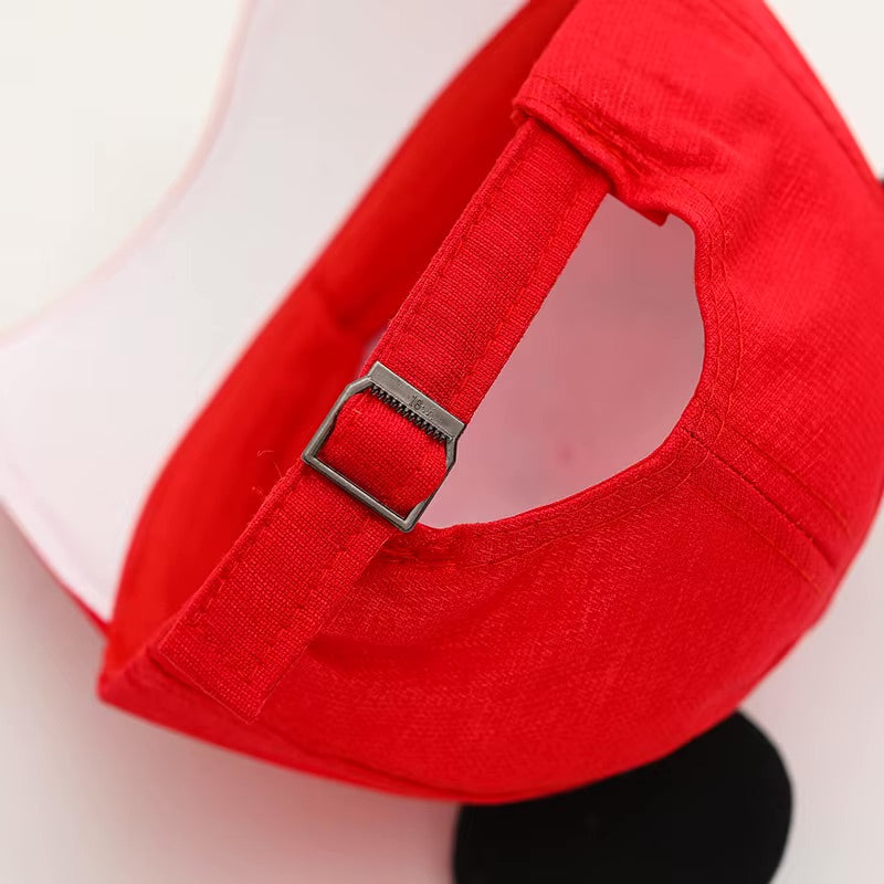 Close-up of a red cap with a strap on a white background