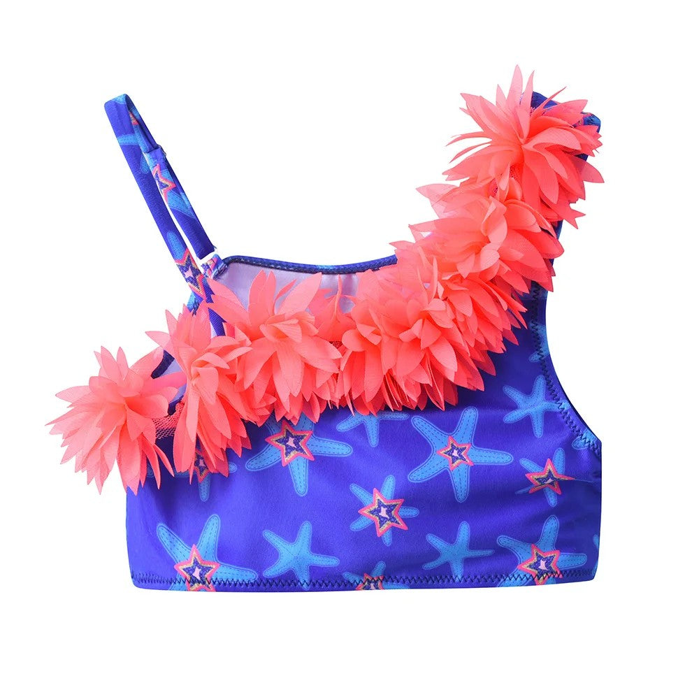 Children's swimsuit with pink floral details and starfish pattern on a blue background