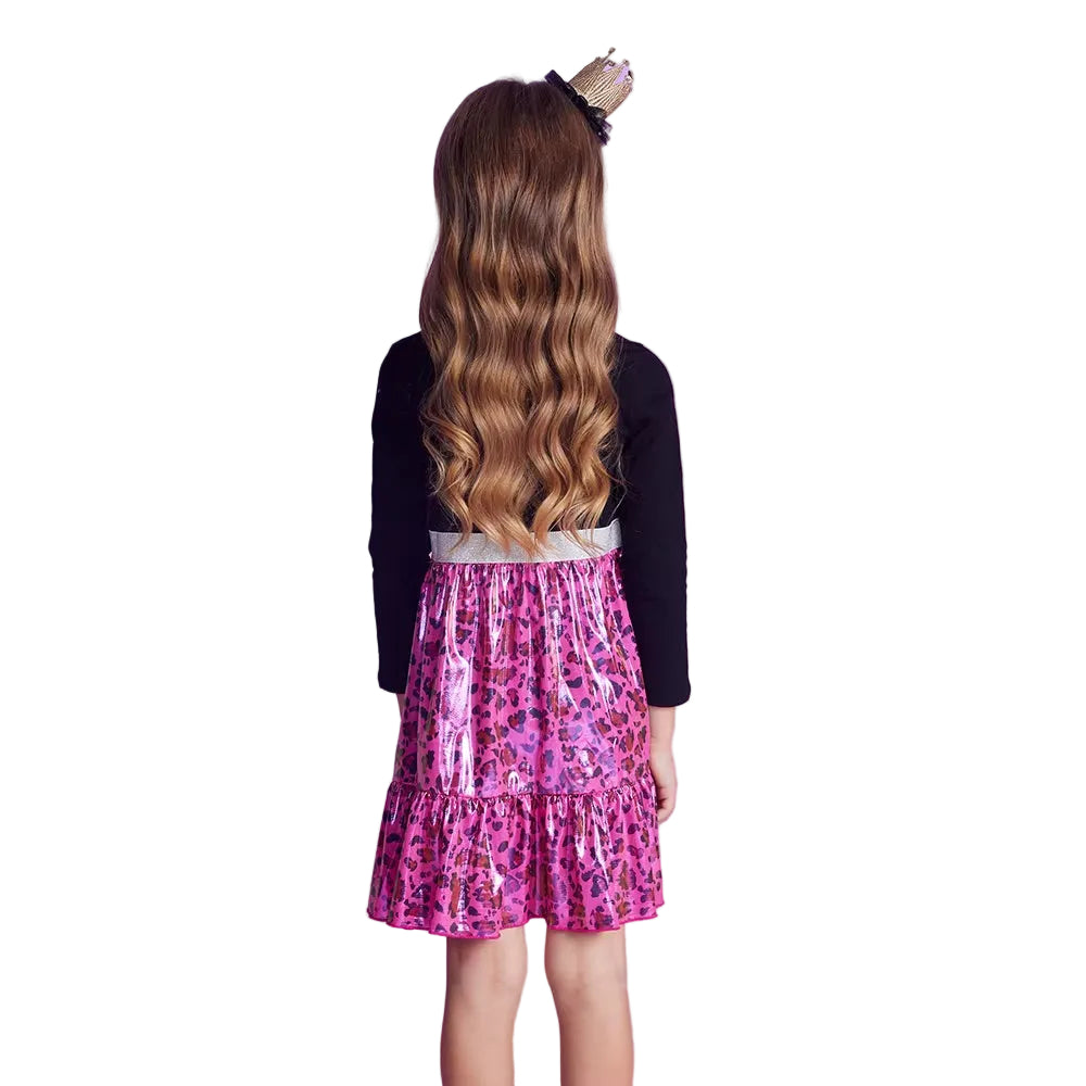 Child wearing a black long-sleeve top and pink leopard print skirt on a white background