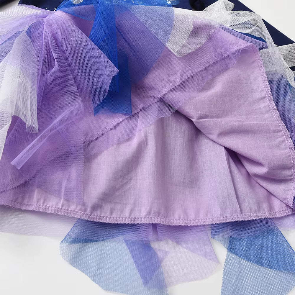 Close-up of a purple fabric with ruffled layers and sheer overlay